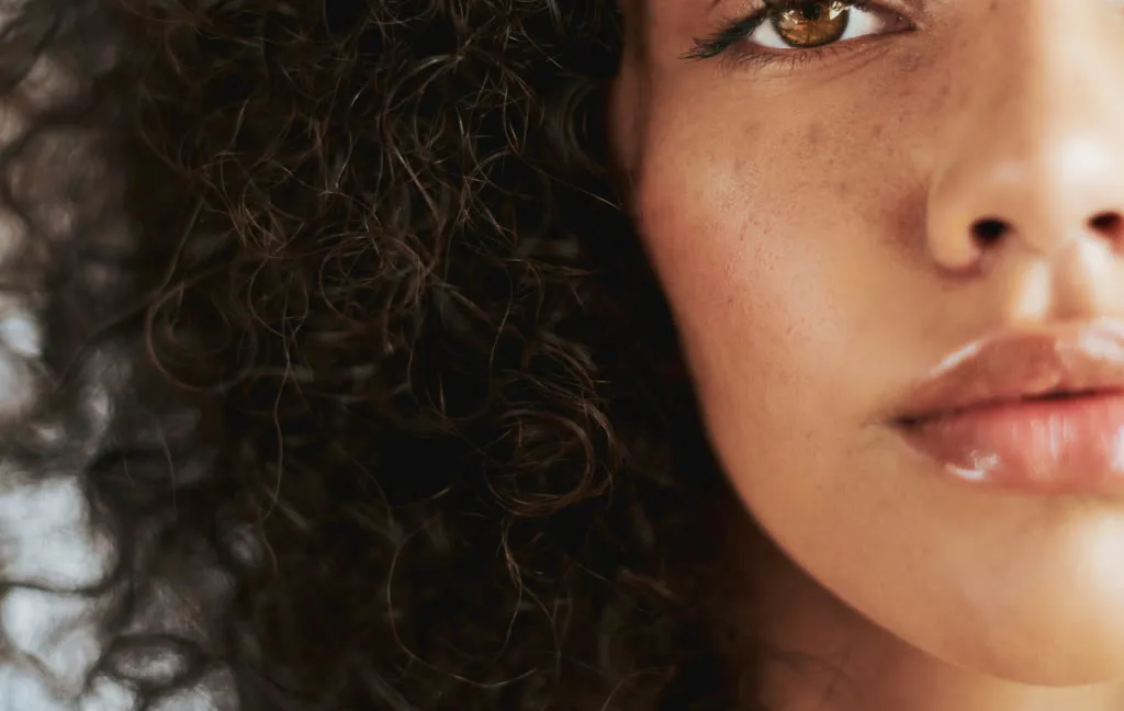 Primer plano de mujer de piel luminosa con pecas